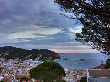 Scenic view of sea by town against sky