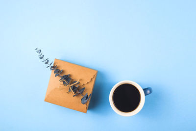 High angle view of coffee cup against blue background