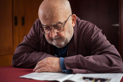 Close-up of man sitting on table at home