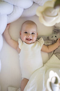 High angle view of cute baby girl lying on bed