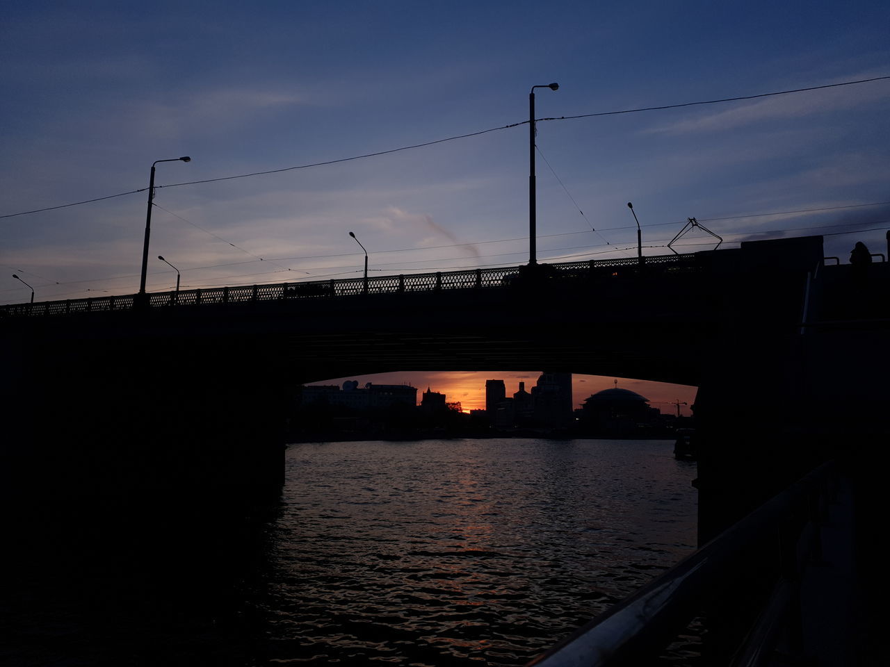 BRIDGE OVER RIVER AGAINST SKY AT SUNSET