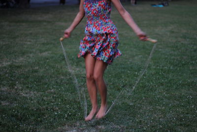 Low section of woman walking on field