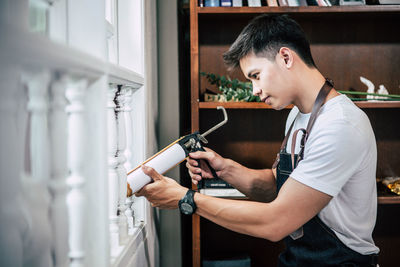 Side view of man looking at camera at home