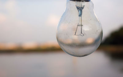 Close-up of light bulb against sky