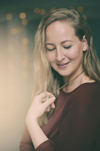 Portrait of a smiling young woman holding camera