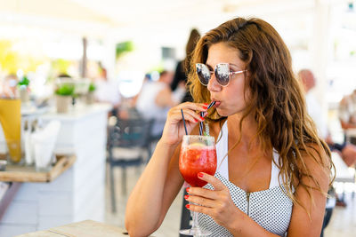 Woman in sunglasses drinking juice