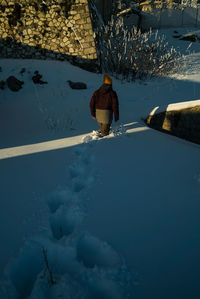 Woman walking by snow covered trees during winter