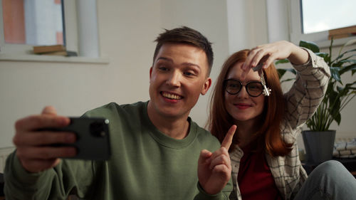 Young couple during video call on smart phone at home