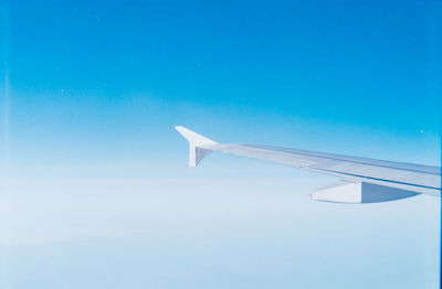 Airplane wing against clear blue sky