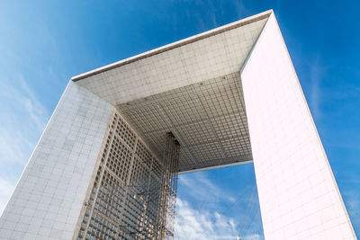 Low angle view of modern office building against blue sky