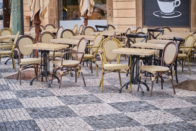 High angle view of chairs and tables and table and lounge chair and woman sitting on wooden floor