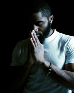 Close-up portrait of man against black background