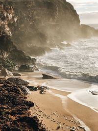 Scenic view of beach against rock formations