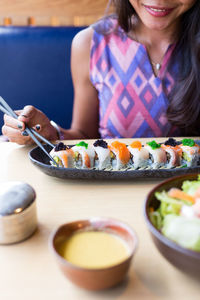 Close-up of young woman eating sushi