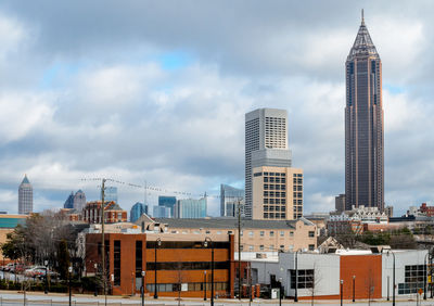 Buildings in city against cloudy sky