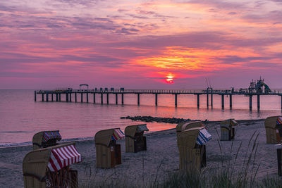 Pier over sea against sky during sunset