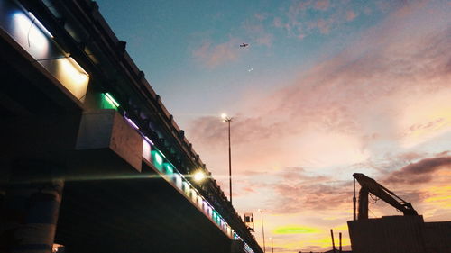 Low angle view of illuminated buildings against sky at sunset