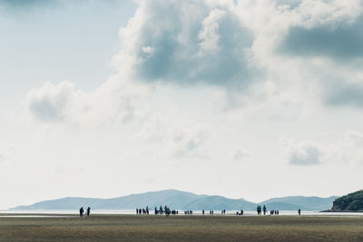 Panoramic view of people on field against sky