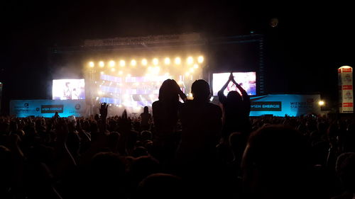 Silhouette of people watching stage performance