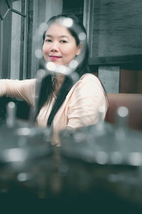 Portrait of a smiling young woman sitting on table