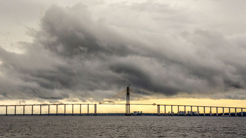 Bridge over sea against sky during sunset