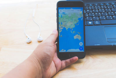 Close-up of man using mobile phone on table