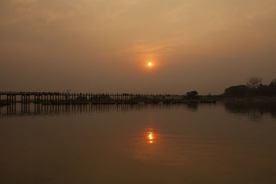 U bein bridge over taungthaman lake against sky during sunset