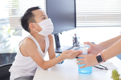 Midsection of woman holding hands on table