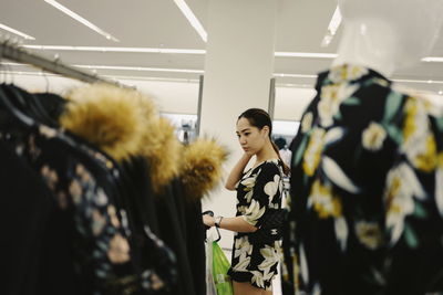 Side view of woman choosing clothes at clothing store