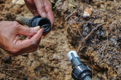 Cropped hands repairing pipe
