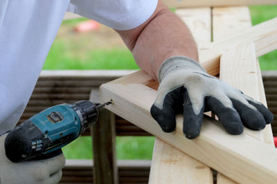 Midsection of man working on wood