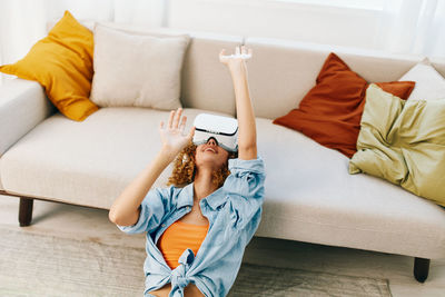 Low section of woman sitting on sofa at home