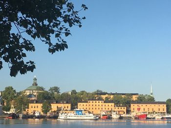 River by buildings against clear sky