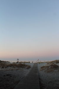 Surface level of empty road against clear sky