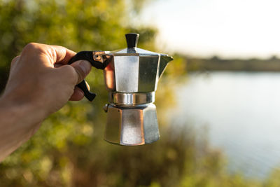 Close-up of hand holding coffee machine