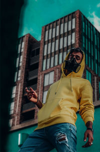 Low angle view of man photographing against built structure