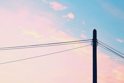 Low angle view of silhouette electricity pylon against sky during sunset