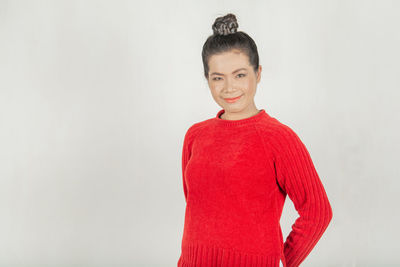Portrait of smiling young woman against white background