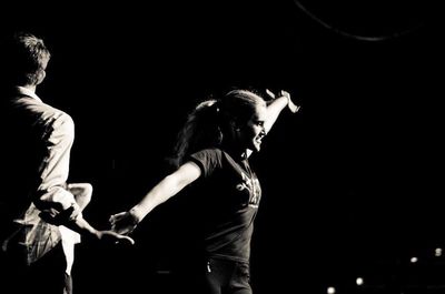 Side view of two people against black background
