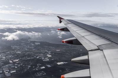 Cropped image of airplane flying over mountains