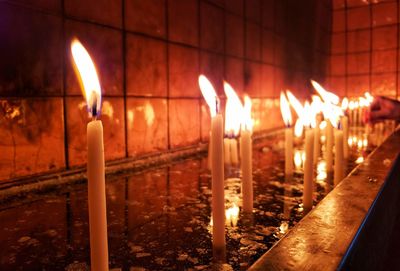 Close-up of lit candles in temple