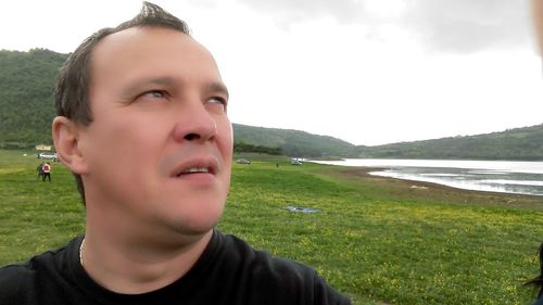 Close-up portrait of man against sky