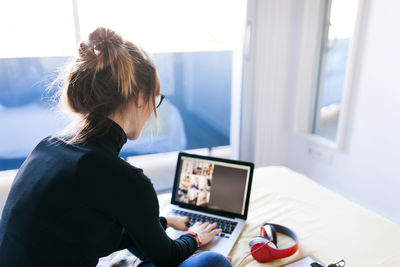 Woman on bed using laptop