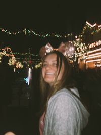 Portrait of smiling young woman at night