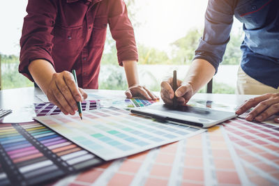 Midsection of businessmen working color swatch in office