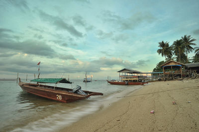 Motorboat at sea shore against sky