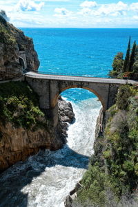 Arch bridge over sea against sky