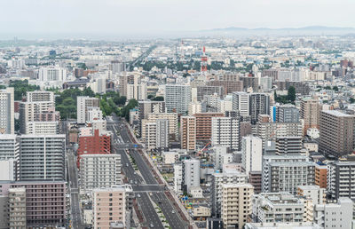 Aerial view of buildings in city against sky