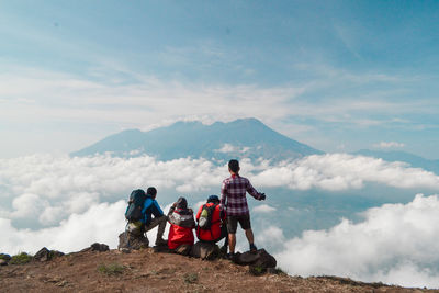 People on mountain against sky