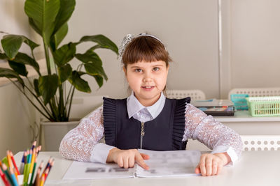 A girl pupul sits at a desk in the classroom and reads a book. back to school concept